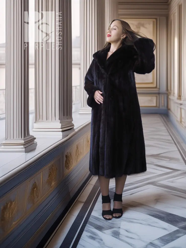 Black mink full-length coat with hooded neckline and side-slit skirt hem.