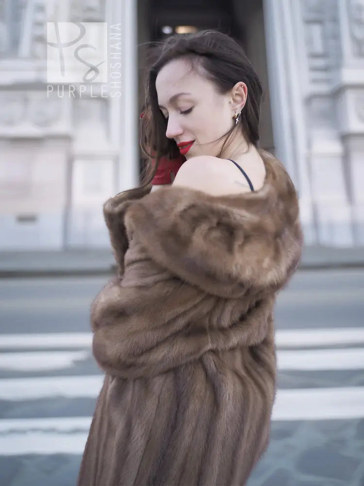 Brown fur coat with thick hooded collar and wrapped, textured sleeves