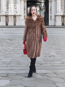 Brown fur coat with hooded collar, long sleeves, and mid-calf length
