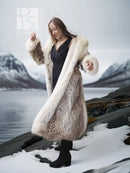 Full-length fur parka with fur-lined hood, cream lining and long coat over black top.