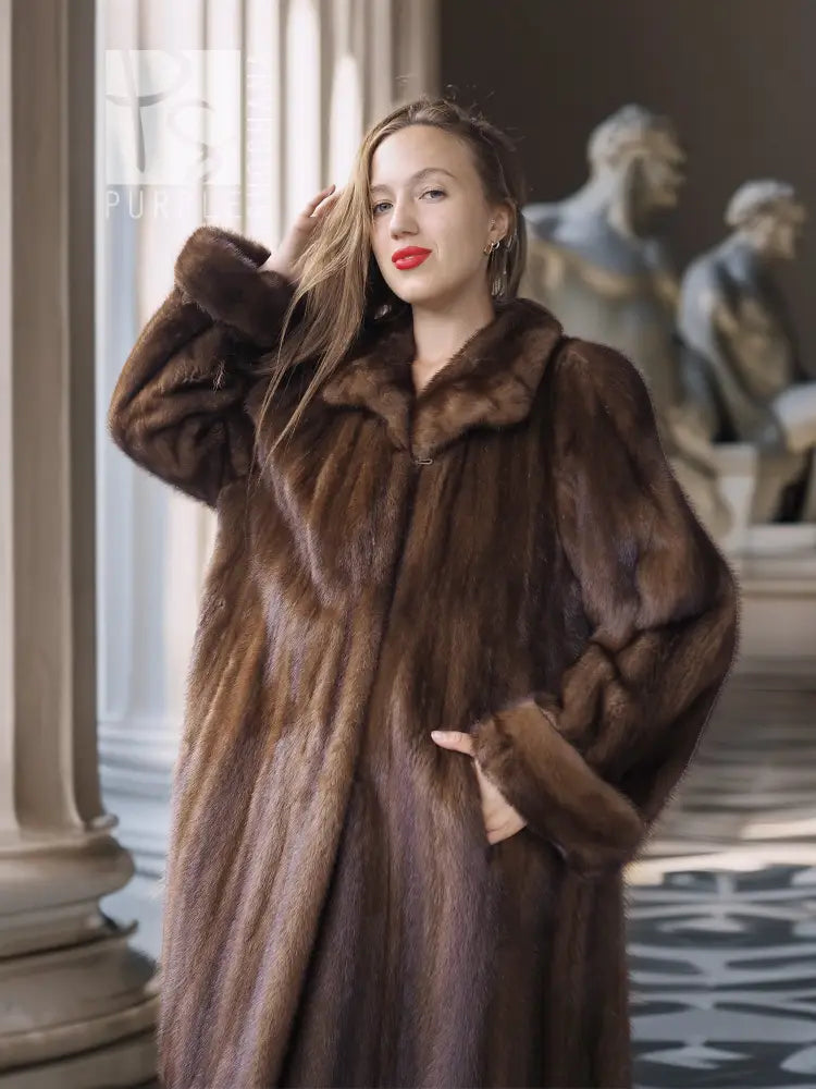 Tan-brown mink coat close-up with wide collar and fur texture, sleeve raised.