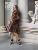 Brown mink swing coat with raised collar and swingy short skirt, side profile