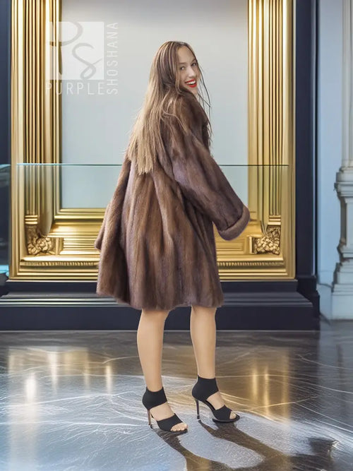 Tan-brown mink swing coat with wide collar and flared sleeves, side view.