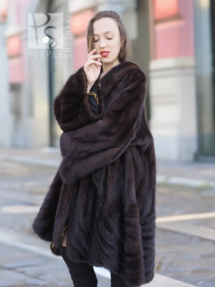 Mink swing coat with plush dark fur and hood, belted silhouette, full-length sleeves