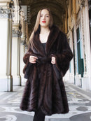 Mink swing coat with dark fur hood and front button closure, flowing swing shape