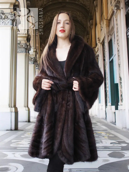 Mink swing coat with dark fur hood and front button closure, flowing swing shape