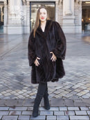 Mink swing coat with dark plush fur, hooded neckline and full swing skirt, side stance