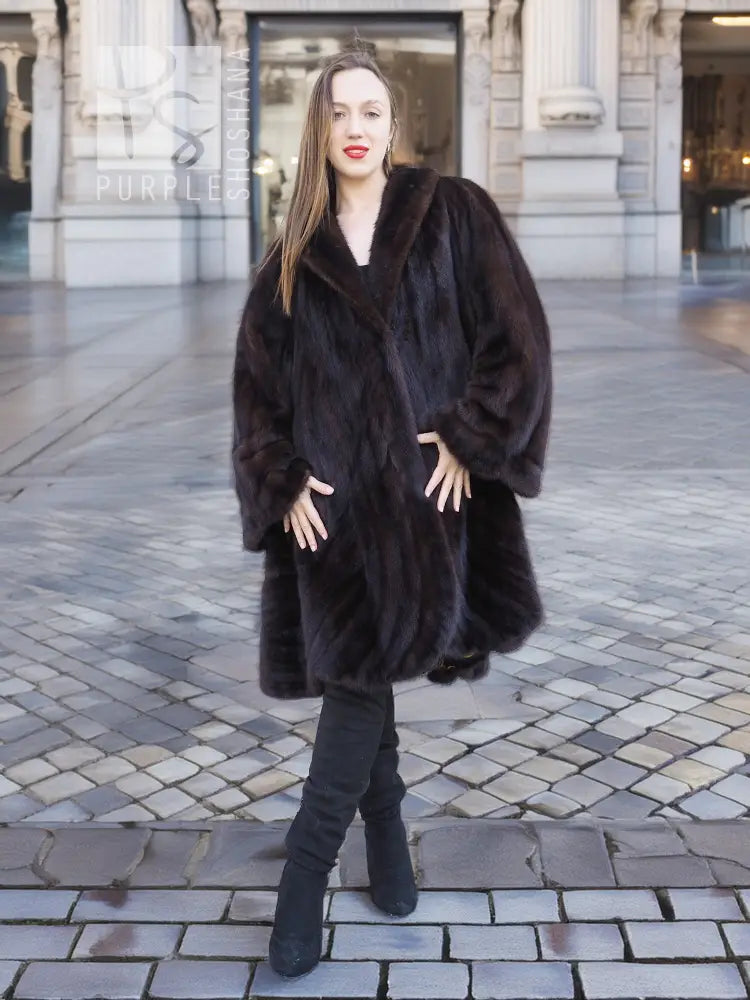 Mink swing coat with dark plush fur, hooded neckline and full swing skirt, side stance