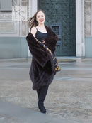 Mink swing coat with dark fur hood, gold baroque lining panels at cuffs and hem