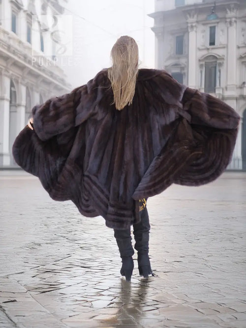Back view of a mink swing coat with dark plush fur hood and flared swing hem