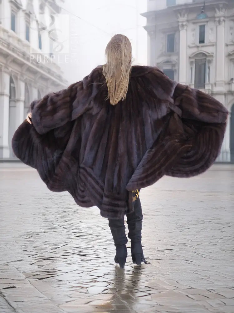 Back view of a mink swing coat with dark plush fur hood and flared swing hem