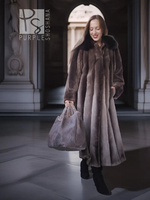 Full-length beaver fur coat with dramatic collar; holding a textured handbag
