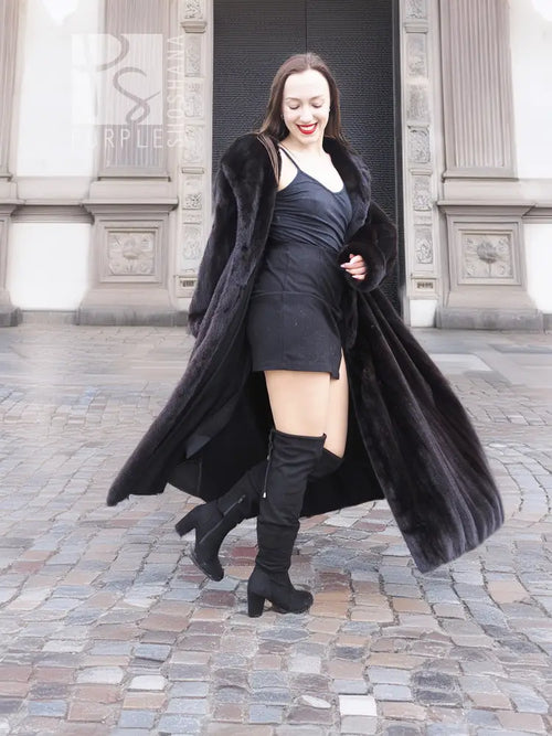 Black mink fur sweep coat with flowing hem and open front, worn with gloves