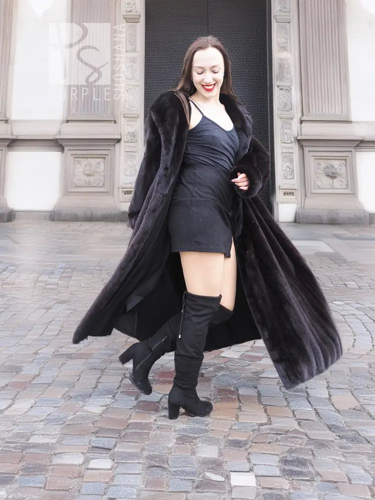 Black mink fur sweep coat with flowing hem and open front, worn with gloves