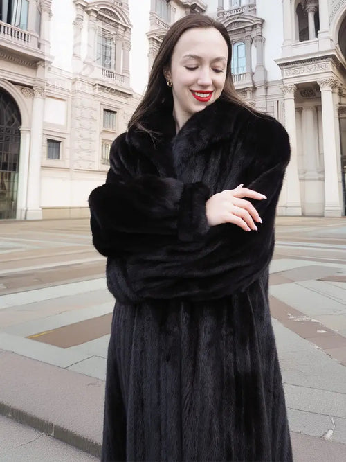 Black mink coat with thick fur sleeves and high collar framing the face