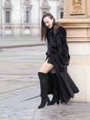 Black mink fur coat with long skirt hem and hooded collar, kneeling side view