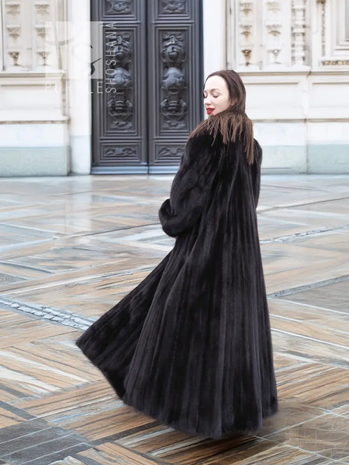 Black mink sweep coat with belted waist and voluminous flare hem