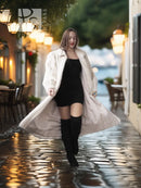 Ivory mink fur coat over a black dress, flowing flare hem and long sleeves