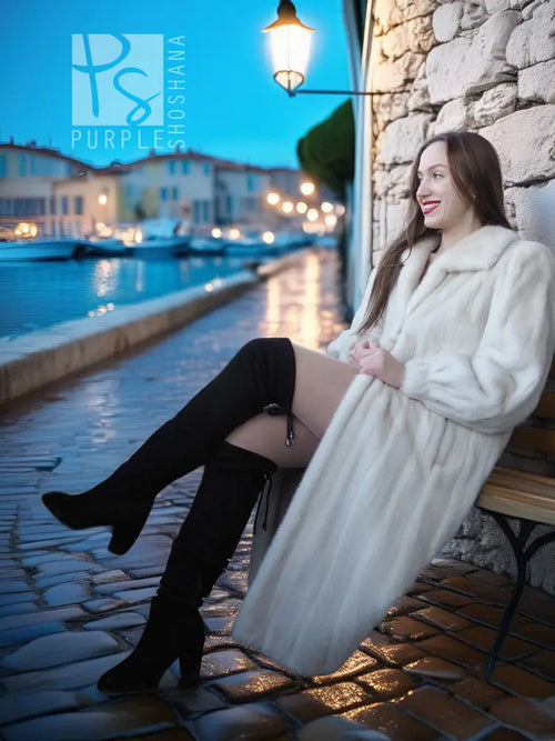 Ivory mink fur coat worn over black outfit, long sleeves and open front