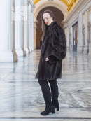 Dark vintage mink swing coat with high collar and long sleeves, curved hem and button.