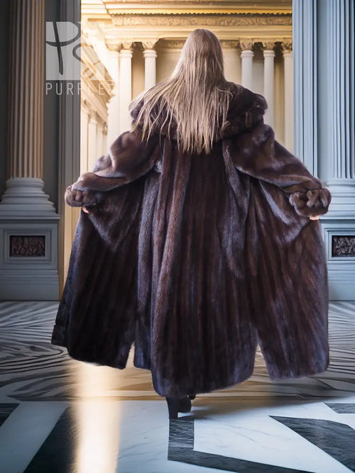 Back view of long dark mink coat with high collar and flowing side-slit hem.