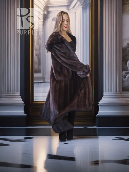 Dark mink coat with high collar and flowing long length, side slit.