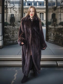 Dark mink coat with buttoned front, standing collar, and side slits.