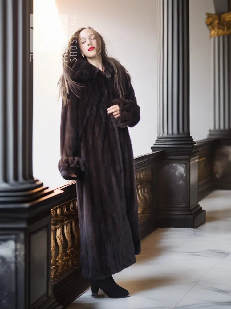 Dark mink fur coat with buttoned front and plush cuffs, long fitted silhouette