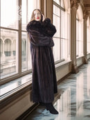 Dark mink coat with wide collar and side slit hem, full length.