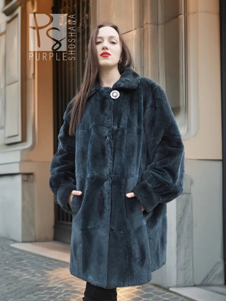Sheared muskrat fur coat in dark teal, front view with stand collar and snap closure