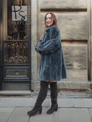 Sheared muskrat fur coat, deep teal, side view with wide cuffs and long sleeves