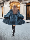 Deep teal muskrat fur coat with flared skirt shape and long sleeves, back view