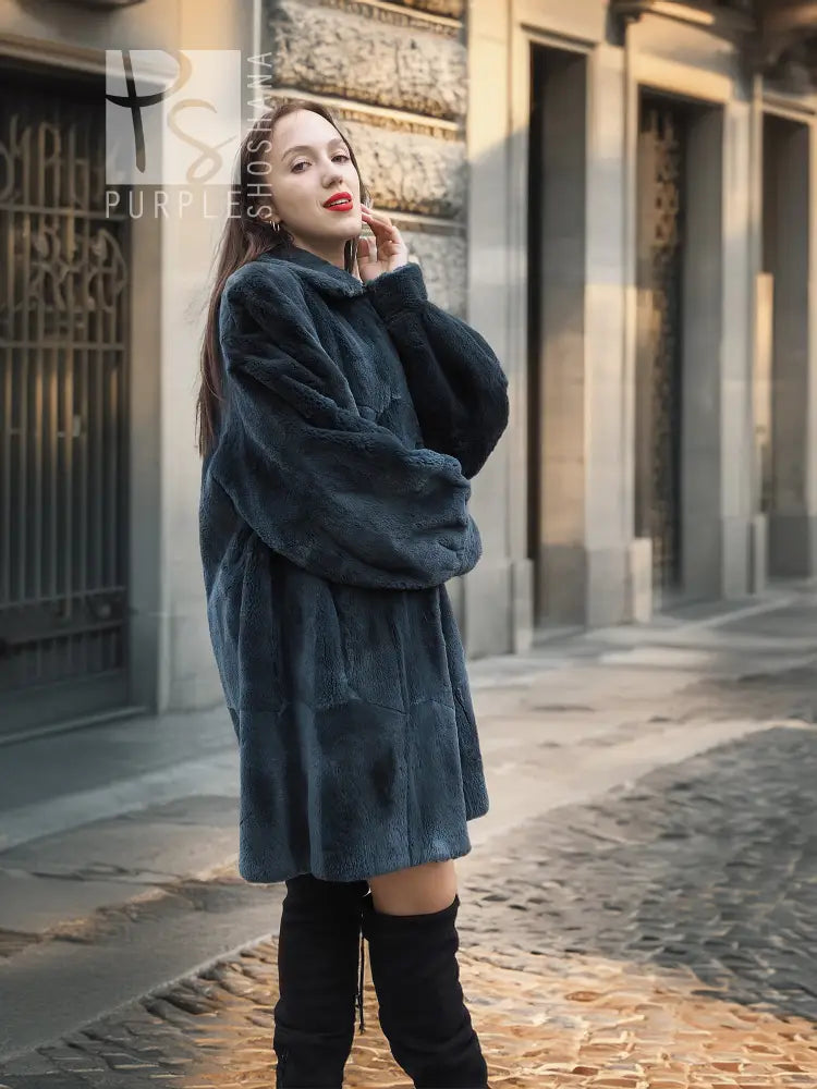 Sheared muskrat fur coat in dark teal with stand collar and snap closure, front view