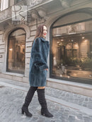 Sheared muskrat fur coat in dark teal, side view with stand collar and snap closure