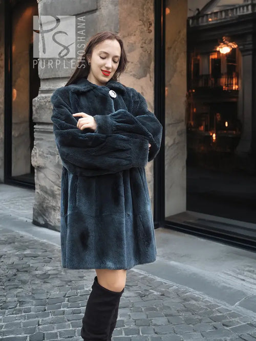 Sheared muskrat fur coat in dark teal with stand collar and snap front, long sleeves