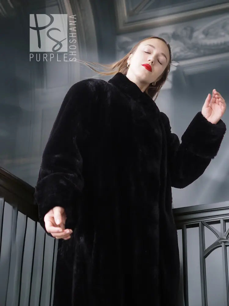 Black sheared beaver fur coat with stand collar; side view, long sleeves and open front.