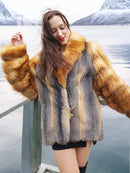 Fur coat with gray textured fabric and orange fox fur cuffs, close-up shoulder view