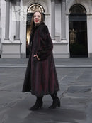 Two-tone mink fur coat, dark with red accents, tall collar and belt, full-length front view