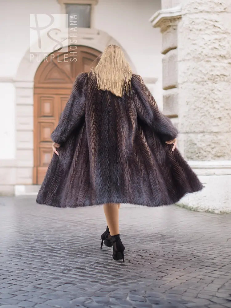 Two-tone muskrat fur coat, dark with light collar and herringbone texture, mid-length