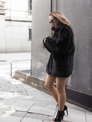 Dark mink fur bomber jacket with wide sleeves, stand collar, and front button placket.