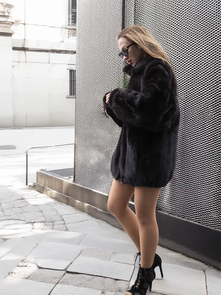 Dark mink fur bomber jacket with wide sleeves, stand collar, and front button placket.