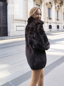 Dark mink fur bomber jacket with voluminous sleeves, stand collar, and short skirt-length hem.