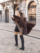 Dark brown fur coat with scalloped fur trim on shoulders, paired with black mini dress.