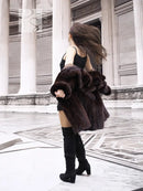 Dark brown mink fur coat with wide collar and cropped sleeves over black dress