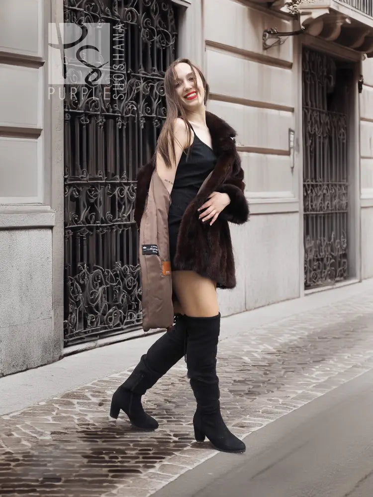 Dark brown fur coat with front buttonless look and wide collar, styled with black thigh boots.