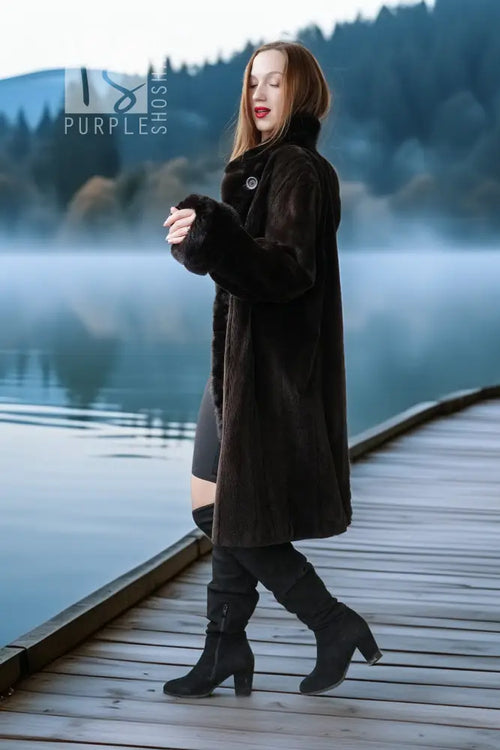 Dark fur button-front coat with stand collar and sleeve cuffs, walking view