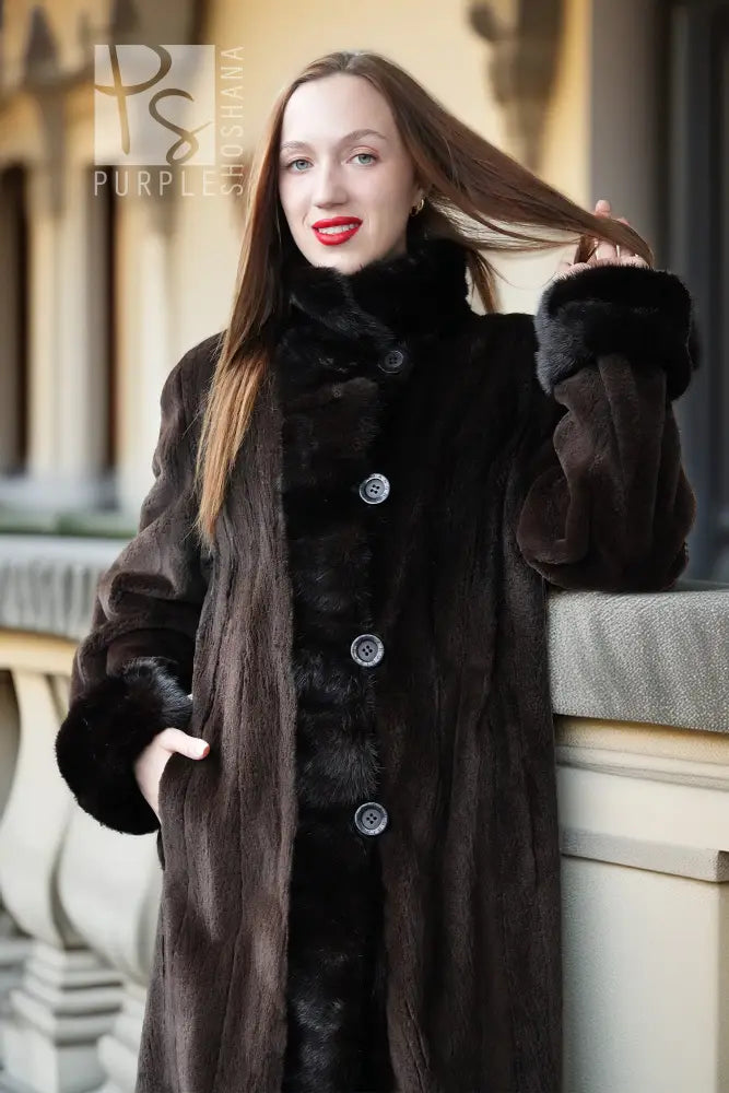 Sheared mink coat with stand collar, dark button front, and fluffy cuffs