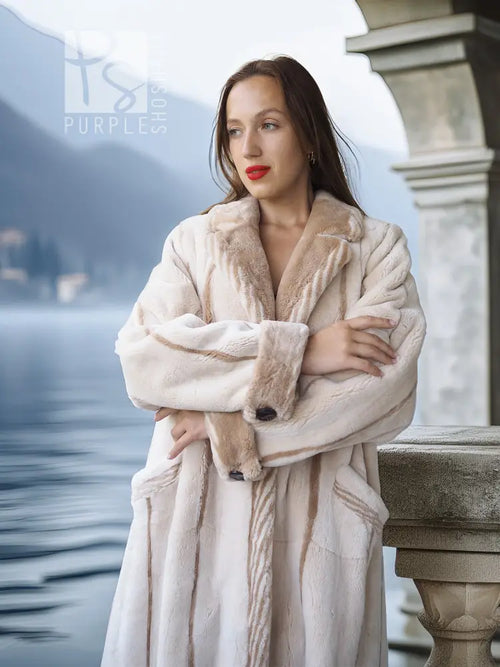 Close view of a cream beaver fur coat with soft texture, notched collar, and button