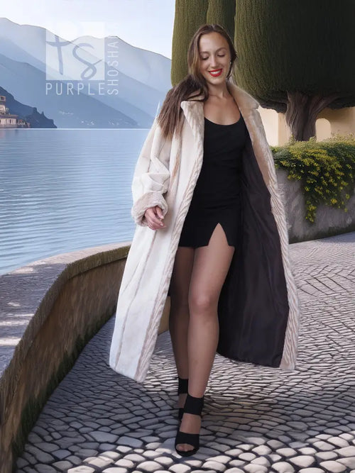 Cream sheared beaver fur coat with open front and textured cuffs; mid-calf length.