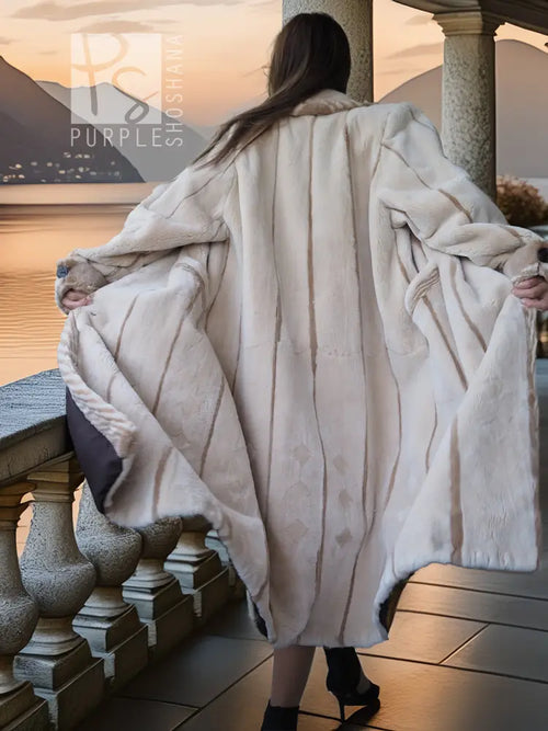 Back view of a cream sheared beaver fur coat with wide shoulders and flowing hem